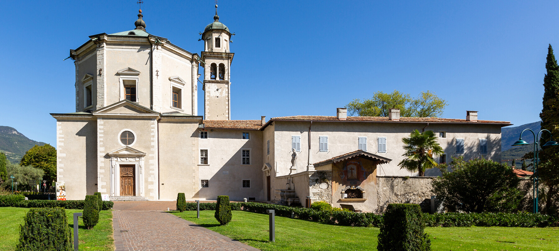 Church of the Inviolata, Riva del Garda. The linear exterior, with clean geometries, hides a Baroque soul. There are no people in the photograph. The church door is closed. Everything seems silent, at peace.
