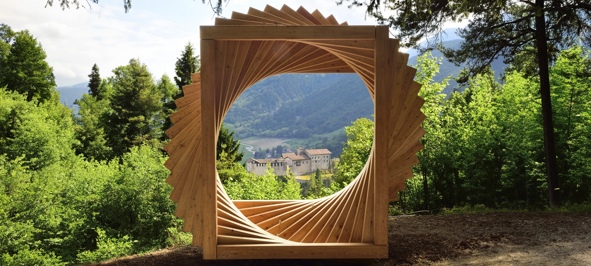 Bosco Arte Stenico, a work by Maurizio Corradi. The work, located at a panoramic point on the path, is a large spiral made up of wooden elements and looks like an open window on the panorama. In the centre, in the distance, is the castle of Stenico. Around the work, the trees of the forest.
