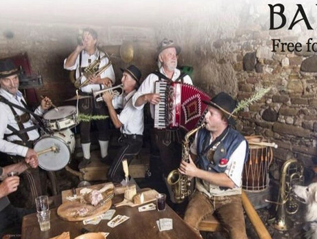 SIX MUSICIANS IN A CELLAR SINGING AND PLAYING WITH A DOG NEARBY