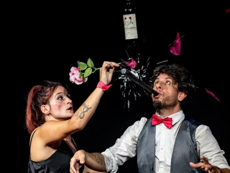 Nell'immagine si vedono i due attori mentre sollevano una bottiglia di vino, sorridendo felici insieme.