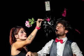 Nell'immagine si vedono i due attori mentre sollevano una bottiglia di vino, sorridendo felici insieme.