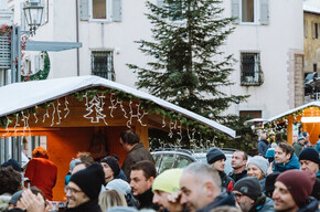 Piazza piena di persone che festeggiano durante le feste natalizie con concerti e casette di prodotti tipici