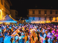 Persone danzano e ascoltano musica nel centro storico del paese all'aperto