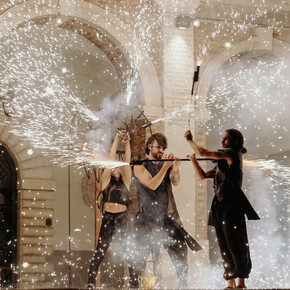 Image of three artists performing a show with fire
