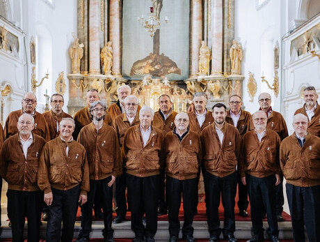 L'immagine mostra i componenti del coro alpino trentino mentre eseguono un concerto in una chiesa