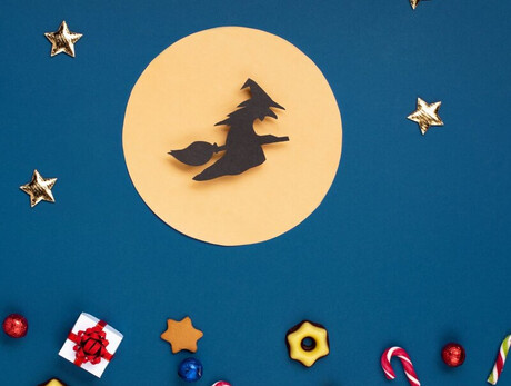 Nell'immagine si vede la befana disegnata su cartincino , mentre vola con la scopa nella luna piena. In basso dei dolcetti decorano il foglio