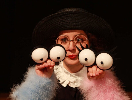 L'immagine mostra l'attrice durante lo spettacolo mentre utilizza due marionette