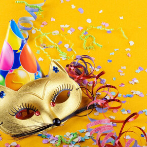 L'immagine mostra una maschera di carnevale, un cappellino e dei coriandoli