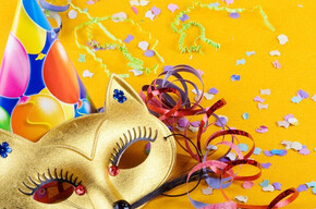 L'immagine mostra una maschera di carnevale, un cappellino e dei coriandoli