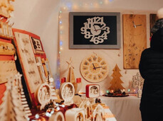The image provides a close-up view of the Faedo Christmas market, focusing in particular on the wooden sculptures and handmade items.