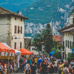 La foto ritrae il paese in festa. Molte persone riempiono il viale principale del paese tra stand enogastronomici e buona compagnia.